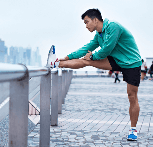 Cotton Wellness shot of male stretching on bridge