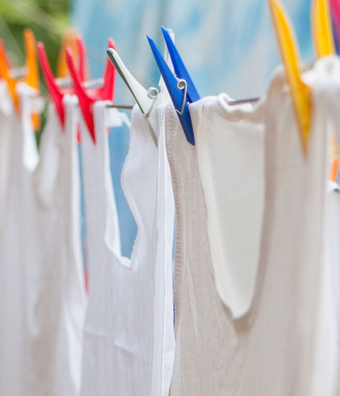 white tank tops on a clothes line with colorful clothespins