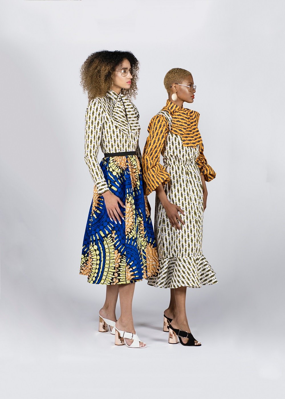 two women wearing ankara print dresses designed by rebuen reuel