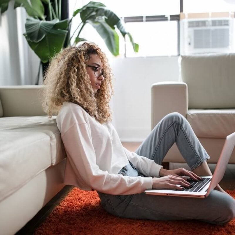 Shop Cotton - gemale lounging with laptop in cotton clothing