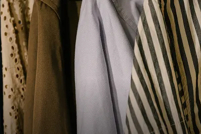 Close-up of various cotton fabrics hanging on a rack, representing The Thread section about fabric innovations and collections