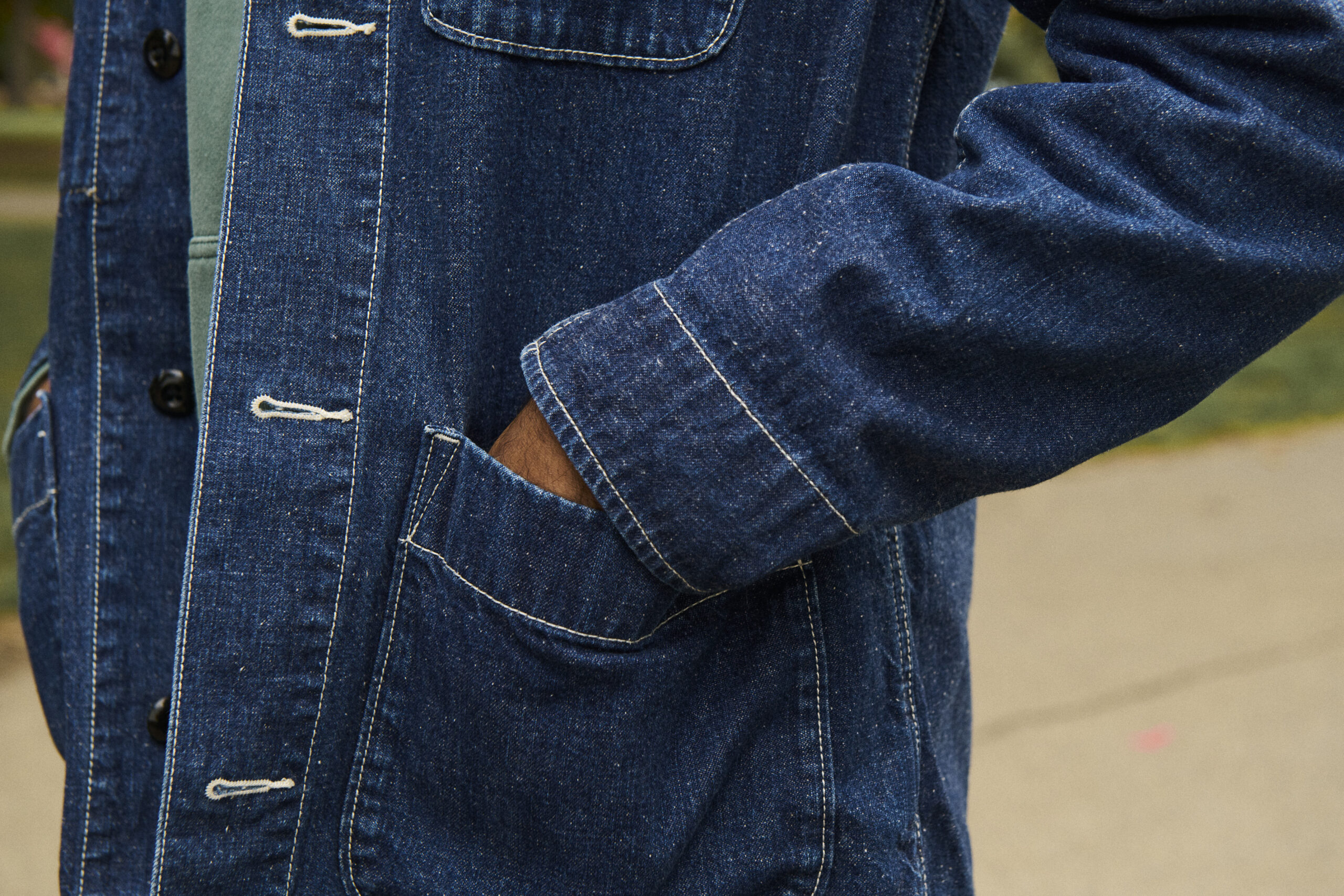 man wearing denim jacket with hand in pocket