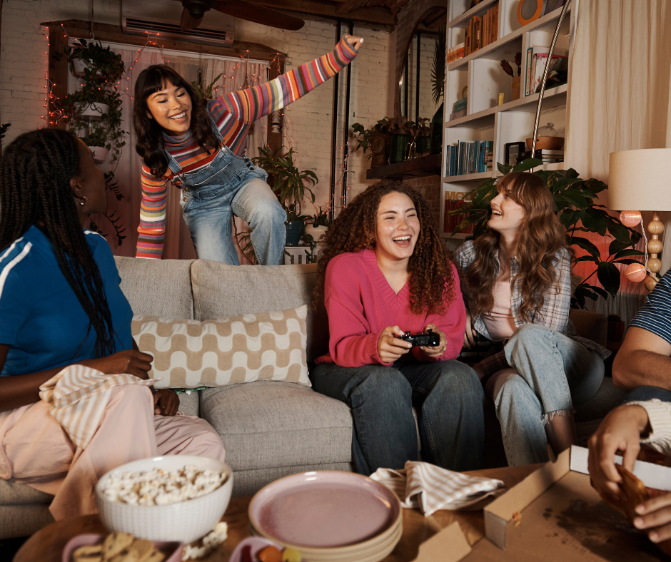 Group of friends relaxing in a cozy living room, wearing comfortable cotton clothing, and enjoying a casual game night.